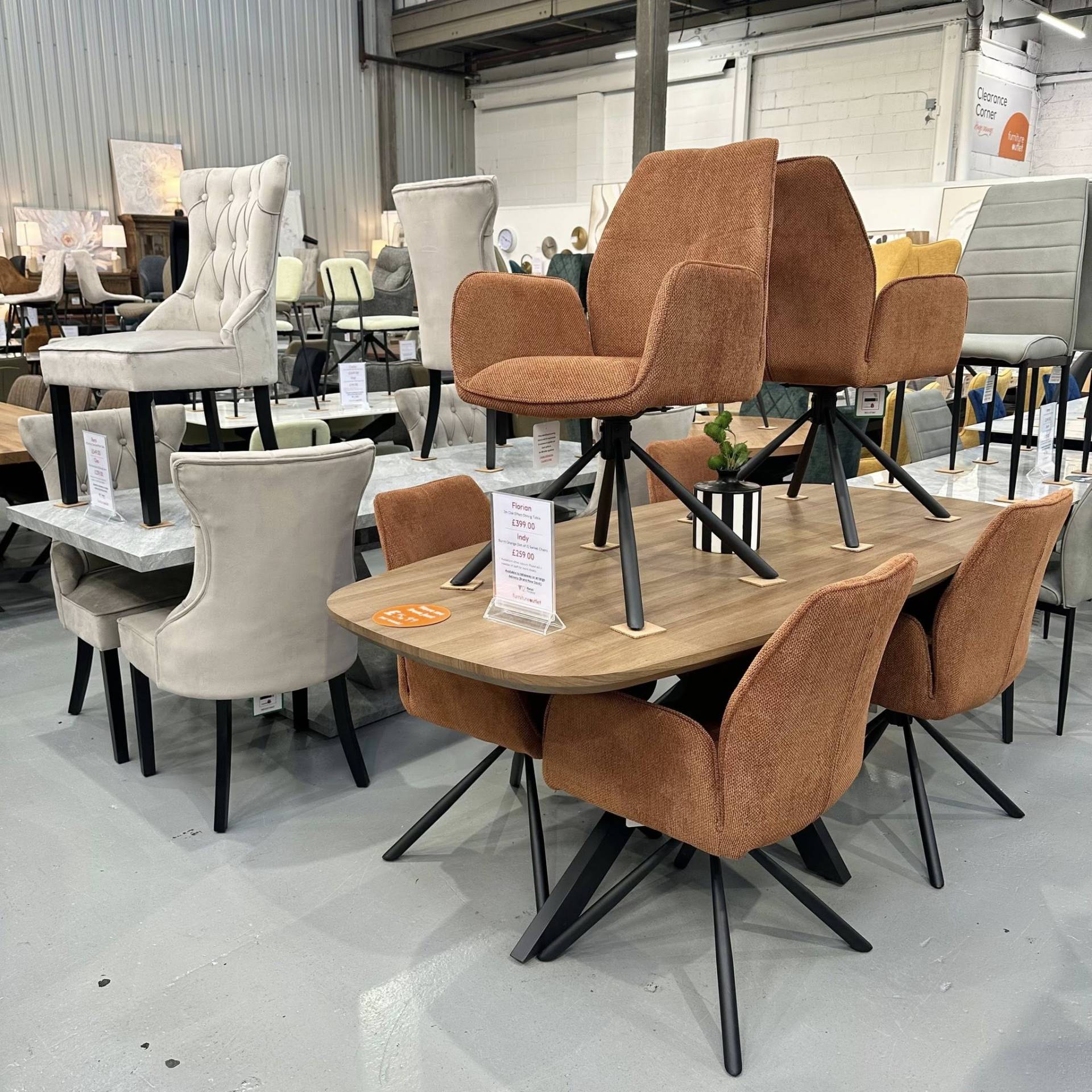 Florian oak effect dining table and burnt orange Indy swivel chairs. A bold, modern set at Furniture Outlet Dagenham
