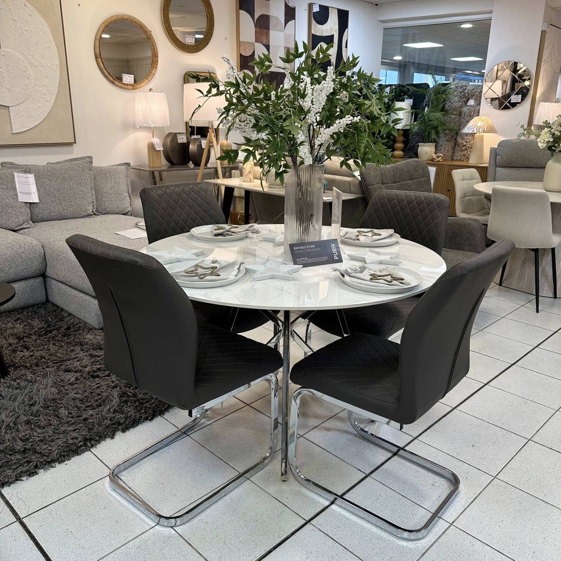 Jeni white stone round table and Cavezzo charcoal chairs. A sleek, modern dining set at Furniture Outlet Leigh-on-Sea
