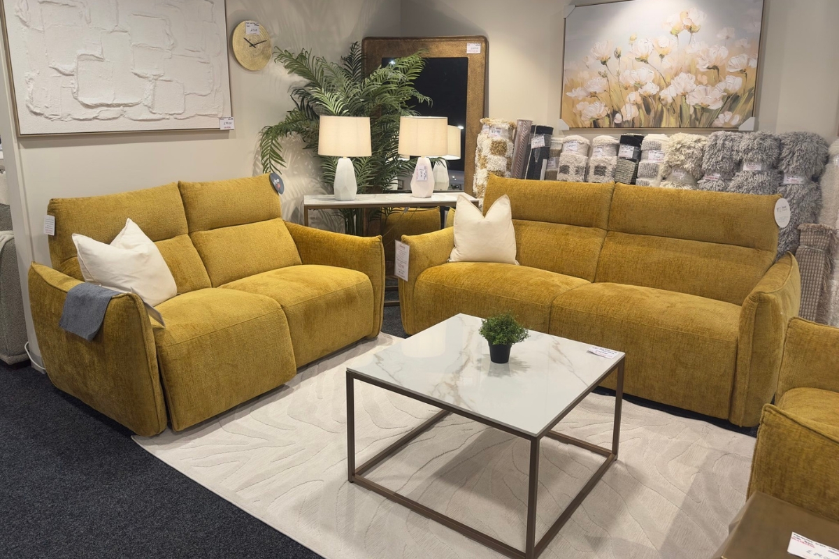 Mustard sofa living room styled in a warm dopamine decor look with lamps, plants and a marble table